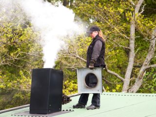 Professional chimney cleaner inspecting and removing creosote buildup